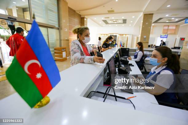 Young man wearing a protective facemask and show document inside ASAN service in Baku on May 20, 2020 in Baku, Azerbaijan. The coronavirus outbreak...