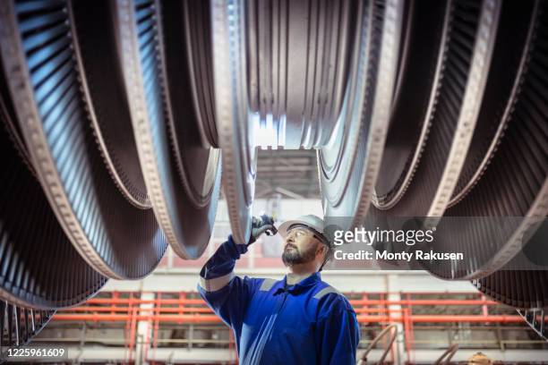 engineer inspecting a turbine in a  nuclear power station. - nuclear power station stock pictures, royalty-free photos & images