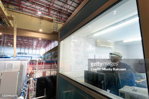 senior engineer in the office in the turbine hall of a nuclear power station. - turbine hall stock pictures, royalty-free photos & images
