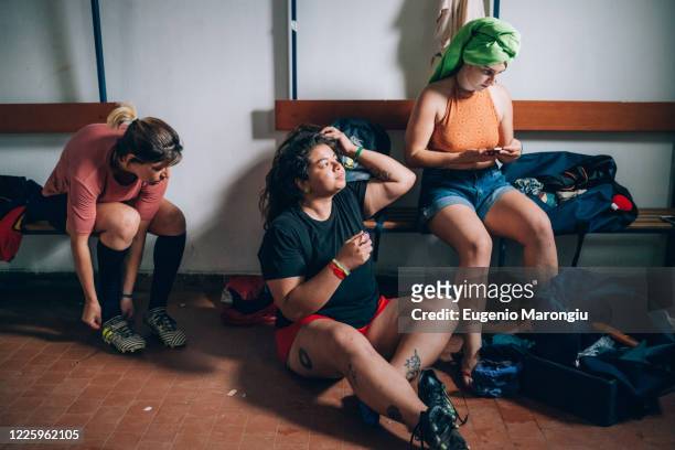 three women sitting in the changing room after rugby training. - rugby players in changing room 個照片及圖片檔