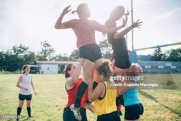 a group of women practicing for rugby lineouts on a training pitch. - rugby boot stock pictures, royalty-free photos & images