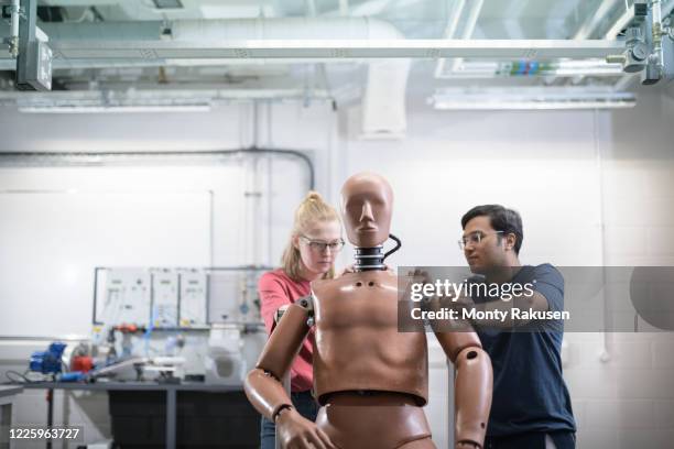 two students working on a test dummy in a workshop. - crash test dummies stock-fotos und bilder