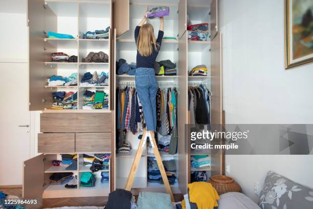 het schikken van garderobe tijdens huisisolatie - organisatie stockfoto's en -beelden