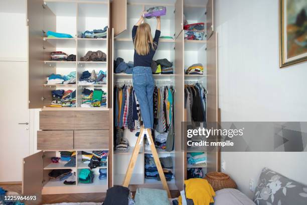 arranging wardrobe during home isolation - arrumado imagens e fotografias de stock