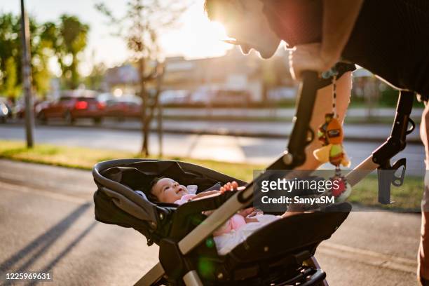 vater und neugeborenes gehen bei sonnenuntergang - baby stroller stock-fotos und bilder