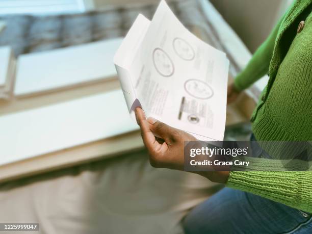 woman reads bookshelf assembly instructions - handboek stockfoto's en -beelden