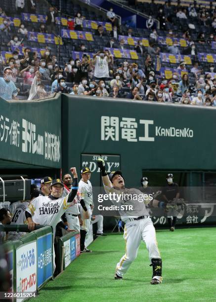 Fans watch SoftBank Hawks player Nobuhoro Matsuda celebrate after hitting a solo home run during the Japanese professional baseball match between...