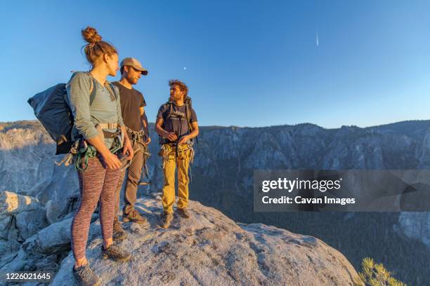 three hikers at the top of el capitan in yosemite valley at sunset - el capitan yosemite national park stockfoto's en -beelden