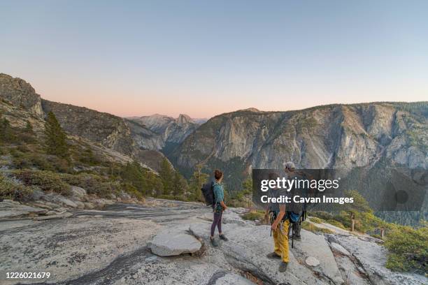 three hikers looking at half dome from el capitan sunset yosemite - el capitan yosemite national park stockfoto's en -beelden