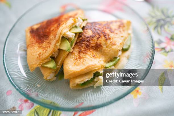 a plate of pancakes with cheese and avocado is on the table with a colorful tablecloth - salt mat bildbanksfoton och bilder