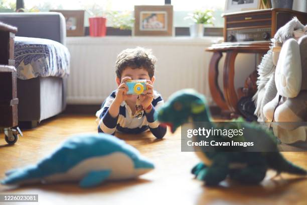 a boy takes photos of his toys with his camera - toy camera stock pictures, royalty-free photos & images