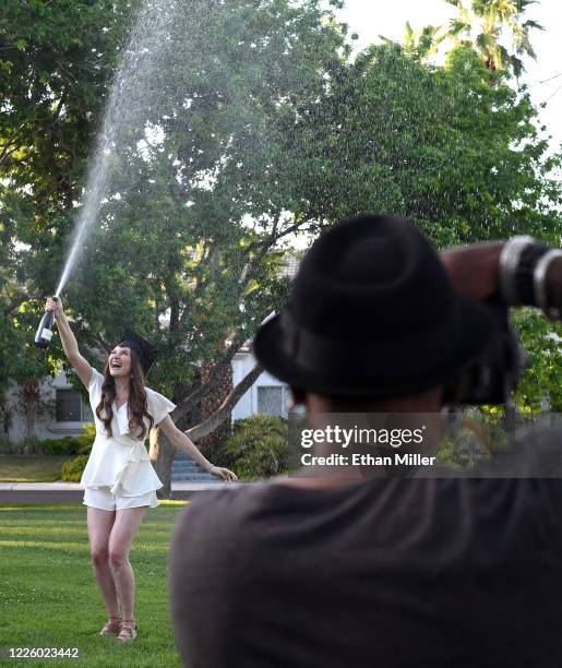 Photographer Jerry Metellus takes commencement pictures of College of William & Mary graduate Julia Carlson spraying champagne in a park across from...