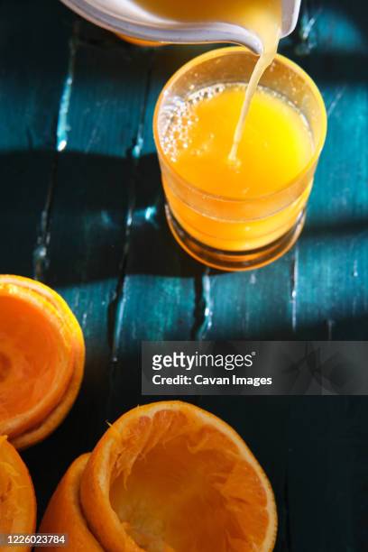 freshly made orange juice in a ceramic squeezer, poured into a crystal - orange juice stock pictures, royalty-free photos & images