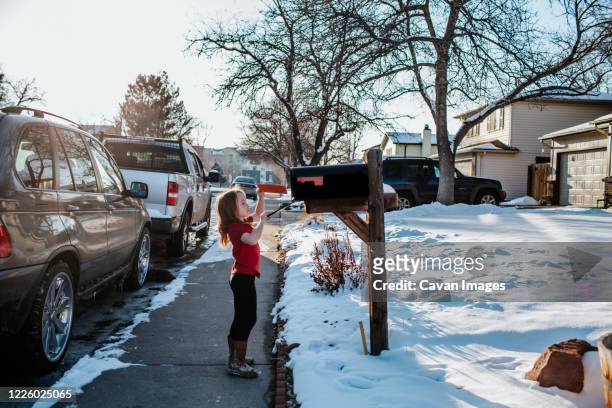 young girl putting letter in mail box - denver street stock pictures, royalty-free photos & images