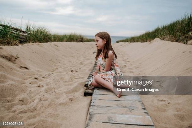 young girl sitting on pathway going out to lake michigan - holland michigan stock pictures, royalty-free photos & images