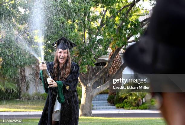 Photographer Jerry Metellus takes commencement pictures of College of William & Mary graduate Julia Carlson spraying champagne in a park across from...