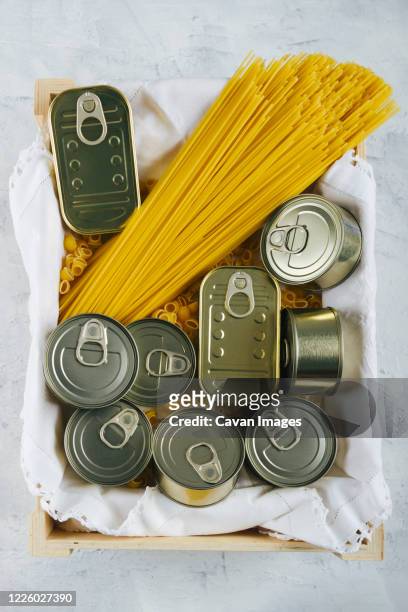 top view of various cans of non-perishable food and spaghetti - estaño fotografías e imágenes de stock
