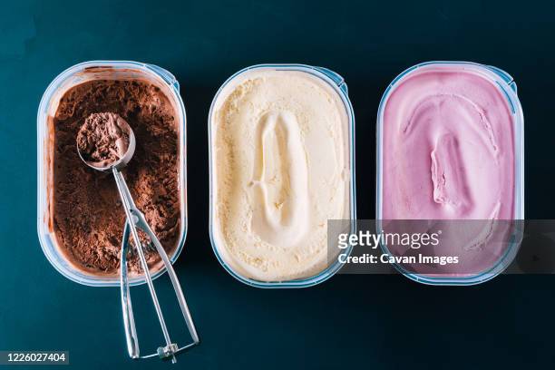 chocolate, vanilla and strawberry ice cream tubs with scoop - frozen yoghurt stock pictures, royalty-free photos & images