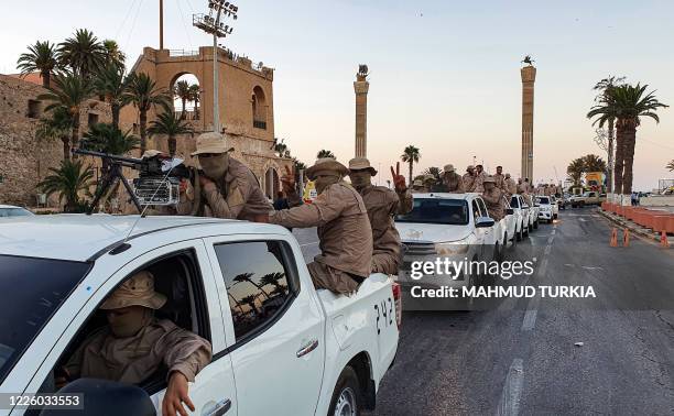 Vehicles of the "Tripoli Brigade", a militia loyal to the UN-recognised Government of National Accord , parade through the Martyrs' Square at the...