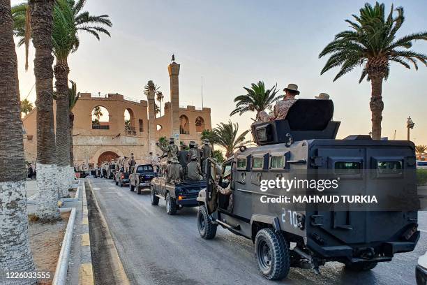 Vehicles of the "Tripoli Brigade", a militia loyal to the UN-recognised Government of National Accord , parade through the Martyrs' Square at the...