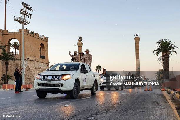 Vehicles of the "Tripoli Brigade", a militia loyal to the UN-recognised Government of National Accord , parade through the Martyrs' Square at the...