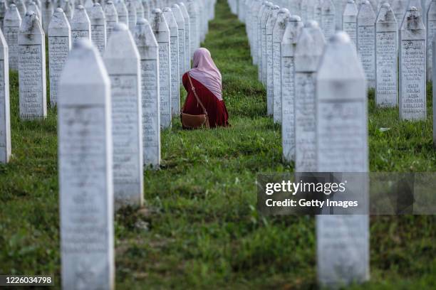 Bosnian Muslim woman cries between graves of her father, two grandfathers and other close relatives, all victims of Srebrenica genocide, July 10 at...