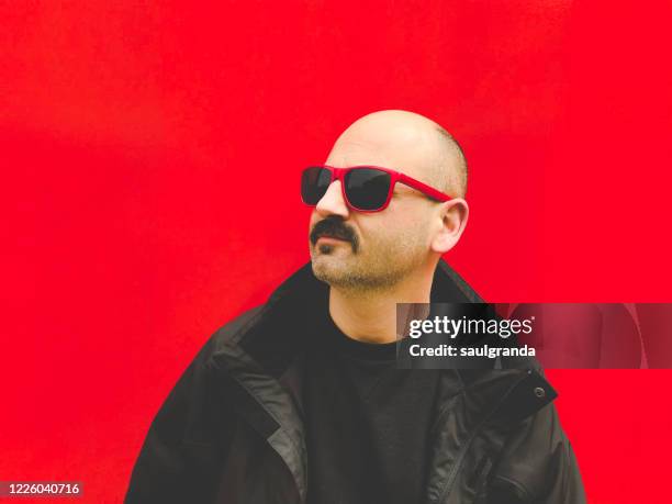 mid adult man portrait against red - completely bald stock pictures, royalty-free photos & images