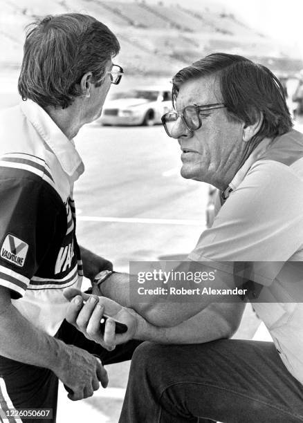 Car owners Leonard Wood, left, and Bud Moore use their stopwatches to time the speeds of their team's cars as they practice prior to the start of the...