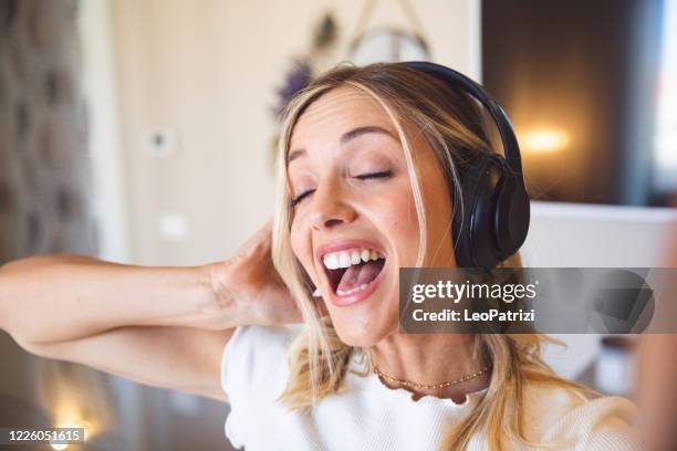 candid portraits of a young blond woman at home - women singing stock pictures, royalty-free photos & images