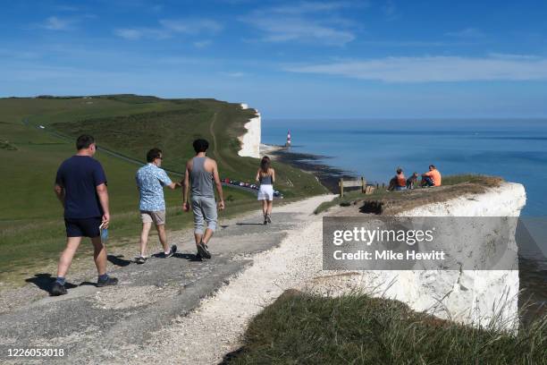 People enjoy the sunshine on the cliff top at Beachy Head on May 20, 2020 near Eastbourne, England. Parts of the country were expected to reach 29...