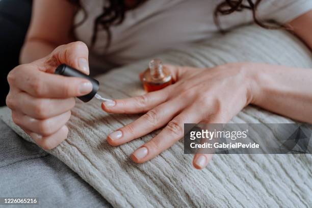 mujer puliendo sus uñas en casa - fingernail fotografías e imágenes de stock