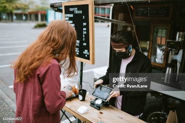 masked customer orders coffee and snacks at food truck - food truck payments stock pictures, royalty-free photos & images