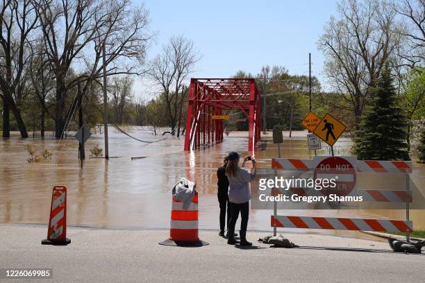 Residents inspect the floodwaters flowing from the Tittabawassee River into the lower part of downtown on May 20, 2020 in Midland, Michigan....