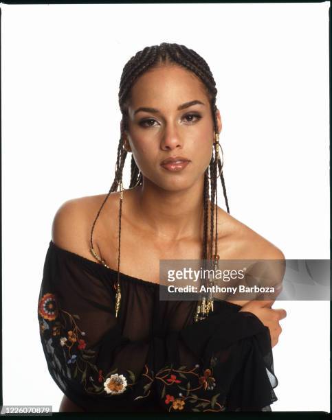 Portrait of American Pop and R&B musician Alicia Keys as she poses against a white background, 2001.