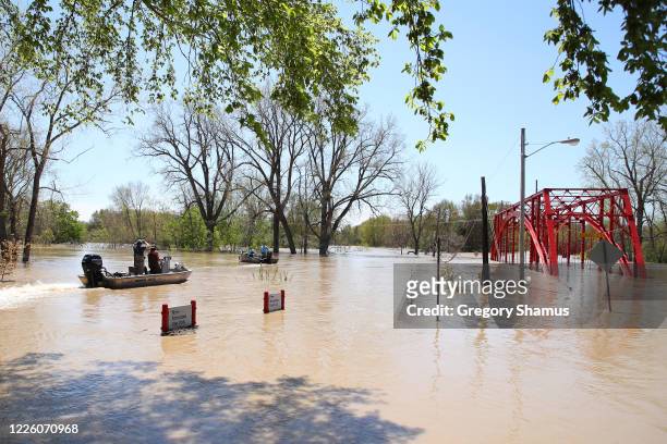 Residents in boats inspect the floodwaters flowing from the Tittabawassee River into the lower part of downtown on May 20, 2020 in Midland, Michigan....