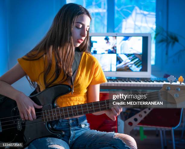 brunette teenager mädchen spielt bass-gitarre-musik-telekonferenz mit ihrer band - rocket internet stock-fotos und bilder