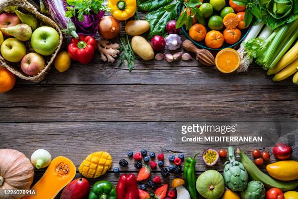 vegetables and fruits vegan food assorted arrangement on wood - vegetable stock pictures, royalty-free photos & images
