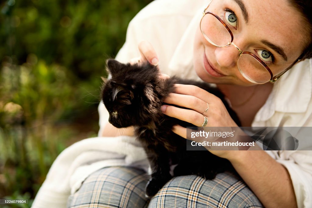 Portrait of young woman with newly adopted kitten.