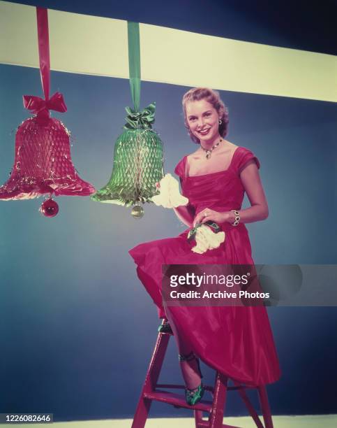 American actress Janet Leigh with four decorative paper bells, circa 1955.