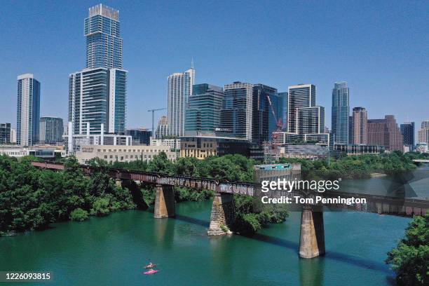 In this aerial view from a drone, residents paddle board and kayak in Lady Bird Lake on May 20, 2020 in Austin, Texas. Texas Governor Greg Abbott...