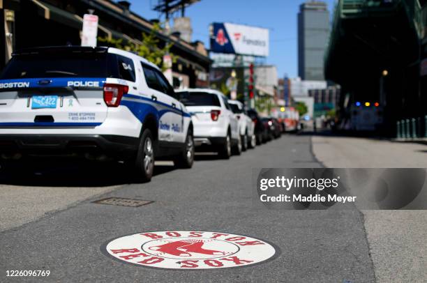 Police cars wait for convoy of 50 ambulances outside of Fenway Park in celebration of National EMS Week on May 20, 2020 in Boston, Massachusetts....