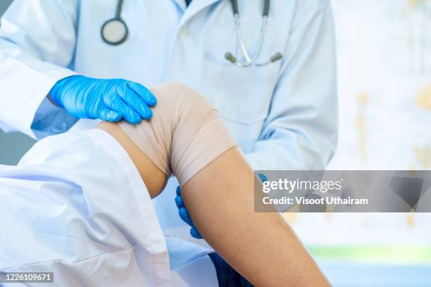 doctor examines the patient's knee. - male knee stock pictures, royalty-free photos & images