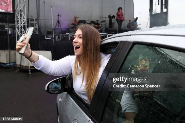 People watch Casey Donovan perform on stage from their vehicles during a media call to showcase how a drive-in live entertainment venue will operate...