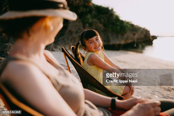 Young girl and mother having fun at beach campsite, Japan