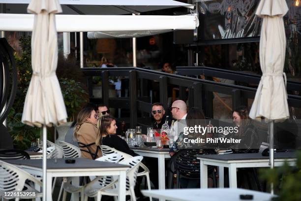 People enjoy socializing with a drink outside at Headquarters in Auckland's Viaduct Basin on May 21, 2020 in Auckland, New Zealand. Bars are able to...