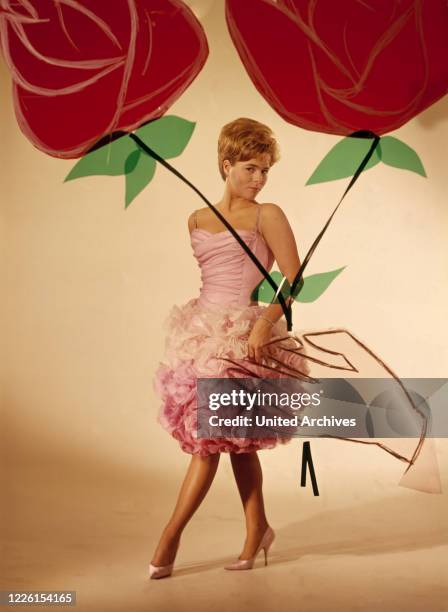 Im weißrosa Cocktailkleid mit Tüllrosen, Modeaufnahme zum Helmut Käutner-Film: 'Der Traum von Lieschen Müller', 1961.