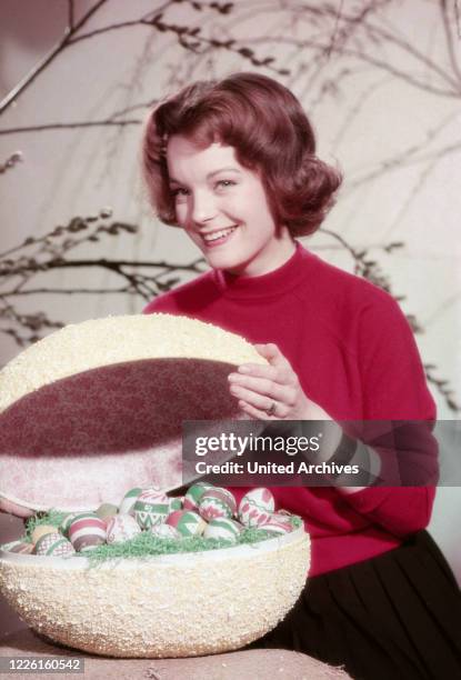 Romy Schneider, deutsche Schauspielerin, mit Osterei, Deutschland 1950er Jahre. German actress Romy Schneider with some eggs for Easter, Germany...