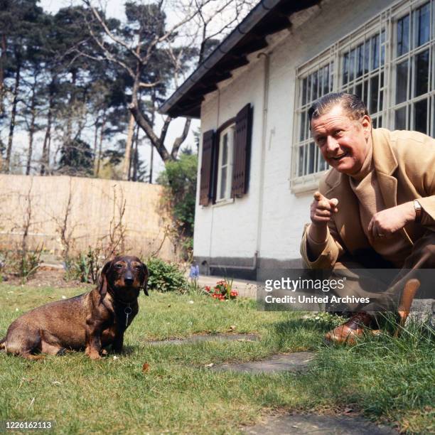 Hans Söhnker, deutscher Schauspieler, mit Dackel im Garten, Deutschland, circa 1960. German actor Hans Soehnker at the garden with his dachshund,...