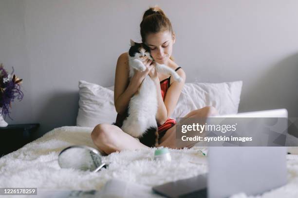 young student hugging cat during break in studies - cat with cream stockfoto's en -beelden