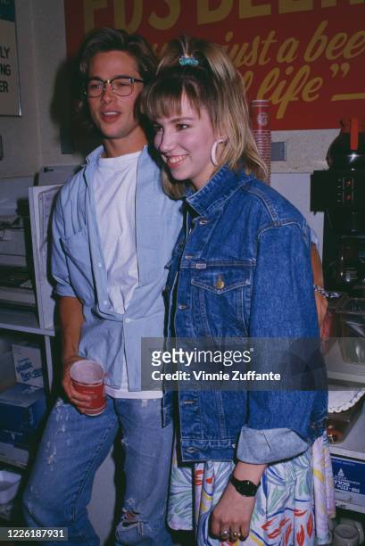 American actor Brad Pitt, wearing a light blue shirt over a white t-shirt, and American singer Debbie Gibson, wearing a denim jacket, attend an...